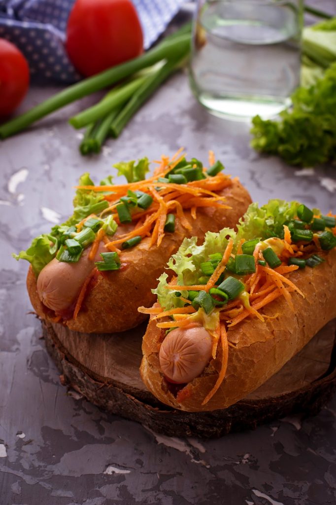 Hot dog with sausage, carrot, onion, lettuce